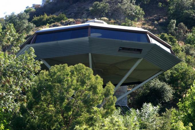 Una casa octogonal que parece una nave espacial encaramada en los árboles.