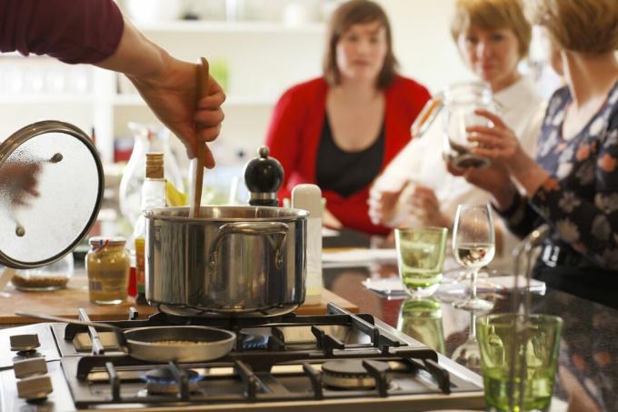 Agitar una olla en una estufa en una isla de cocina permite la interacción con los invitados a la cena.