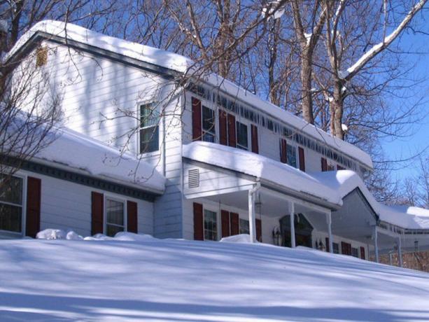 El blanco colonial de un propietario se pierde en la blanca nieve