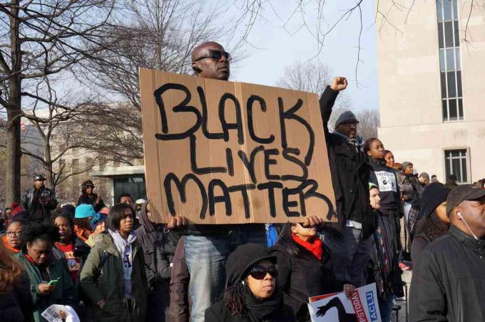 Hombre protestando por la muerte de Michael Brown, Eric Garner y Tamir Rice muestra Black Lives Matter en Washington DC.
