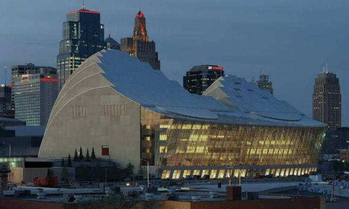 Presione la fotografía del Kauffman Center Hall y el lado de la terraza, al atardecer, Kansas City al fondo.