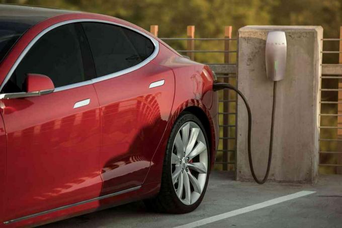 Coche eléctrico Tesla Motors cargando en un estacionamiento público