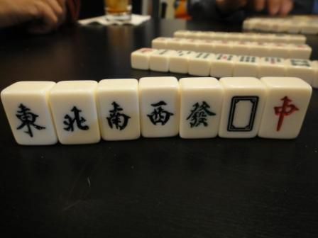 Los azulejos de vientos y dragones en un juego de Mahjong de pie sobre una mesa.