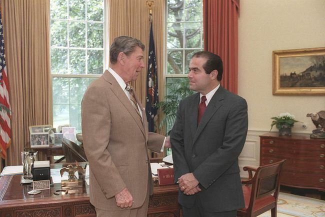 El presidente Ronald Reagan hablando con el candidato a juez de la Corte Suprema Antonin Scalia en la oficina oval, 1986.