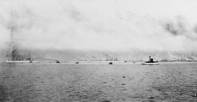 Acorazados de la Gran Flota Blanca en puerto con la flota japonesa. Pequeña embarcación en primer plano.