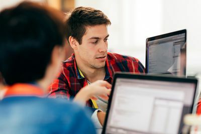 Dos hombres codificando en computadoras