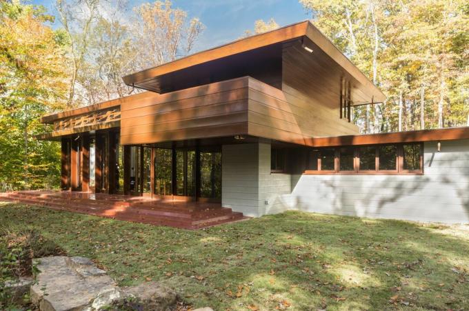 casa de madera, concreto y vidrio de varias capas, techos planos, entrada escalonada, filas de ventanas