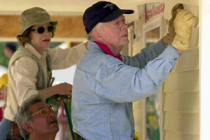 El ex presidente de los Estados Unidos, Jimmy Carter, y su esposa Rosalyn colocan un revestimiento en el frente de una casa de Habitat for Humanity que se está construyendo el 10 de junio de 2003 en LaGrange, Georgia.