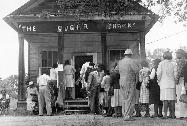Los votantes afroamericanos, que pudieron votar por primera vez en la zona rural del condado de Wilcox, Alabama, hacen fila frente a un colegio electoral después de la aprobación de la ley federal de derecho al voto en 1965.