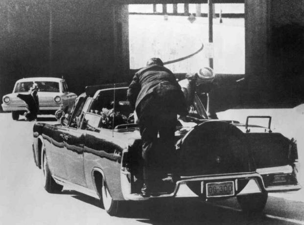 Hombre del servicio secreto subiendo al auto del presidente Kennedy