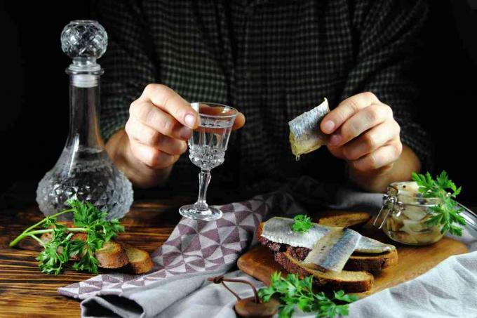 Comida rusa de arenque en vinagre y vodka