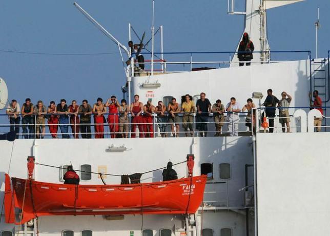 Piratas somalíes que sostienen el buque mercante MV Faina, parados en la cubierta del barco con miembros de la tripulación el 19 de octubre de 2008.