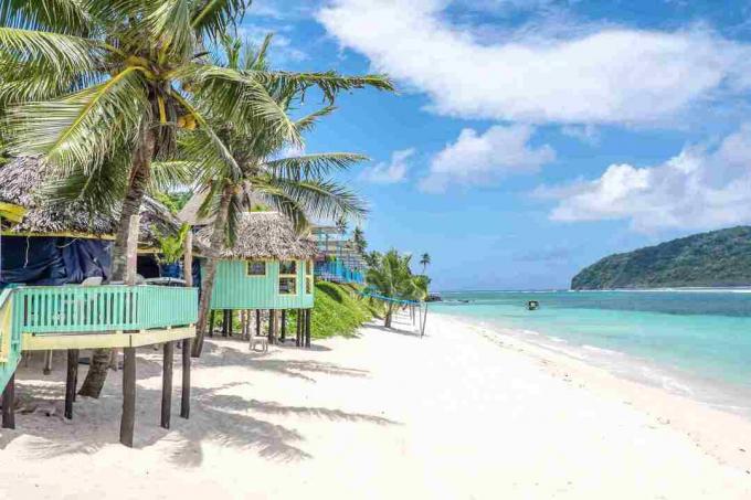 Vea a lo largo de la playa de Lalomanu, la isla de Upolu, Samoa, las coloridas cabañas de playa de Samoa que son una alternativa al alojamiento en hoteles o resorts