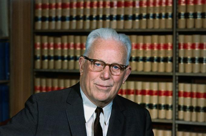 Fotografía en color del ex presidente del Tribunal Supremo de Estados Unidos, Earl Warren, sentado en su biblioteca legal.