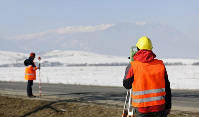 agrimensor trabajando en campo de invierno