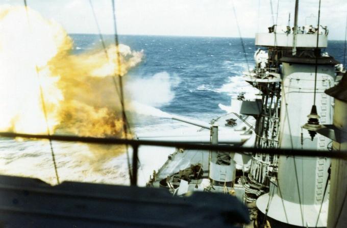 Mirando a popa en el acorazado USS Colorado con cañones de 16 pulgadas disparando.