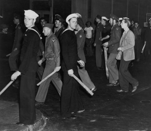Pandillas de marineros e infantes de marina estadounidenses armados con palos durante los disturbios de Zoot Suit, Los Ángeles, California, junio de 1943.