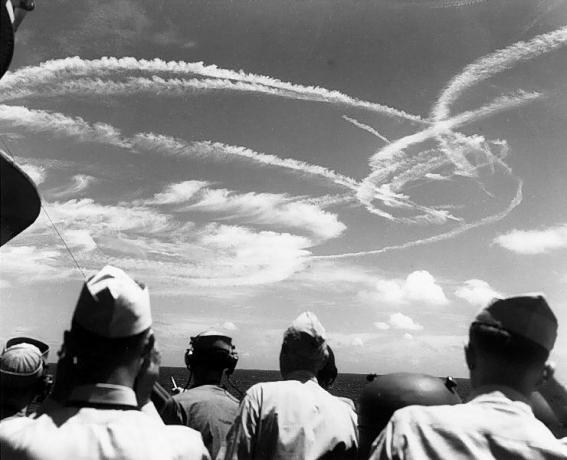 Los marineros estadounidenses mirando hacia el cielo en las estelas formadas por aviones que luchan por la flota.