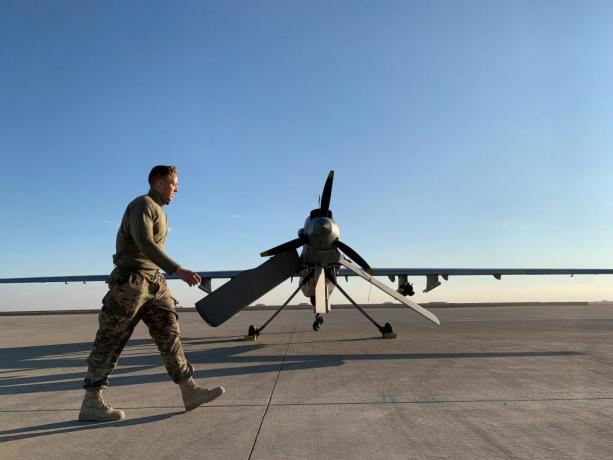 Un miembro de las fuerzas estadounidenses que pasa junto a un avión no tripulado en la base aérea de Ain al-Asad